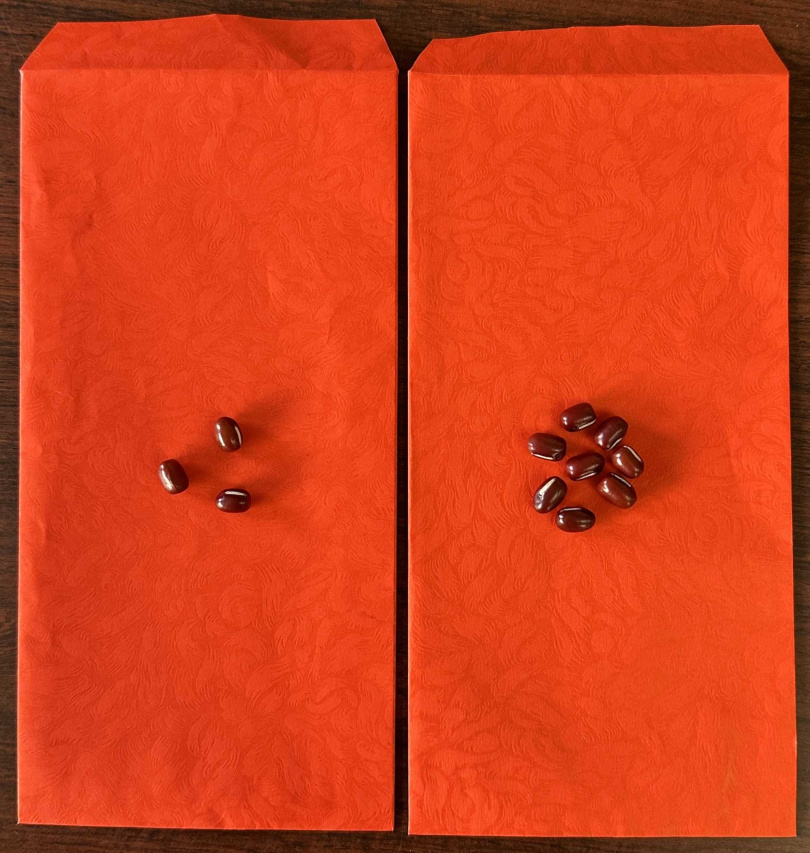 紅包一個包3顆紅豆,另一個包8顆紅豆,分開放在左右口袋,或一起放在錢包裡,因為紅色屬火,3及8的易經數理為「木」的能量。(圖/楊登嵙提供)