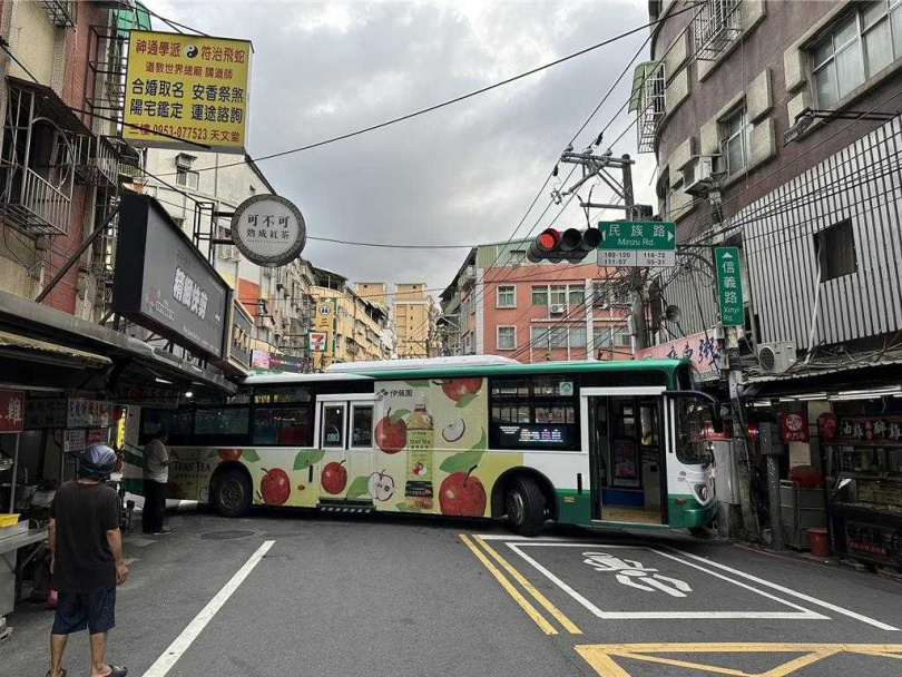 三重客運學生專車9日在蘆洲民族路轉彎時不慎撞到招牌,使車輛進退不得。(圖/蘆洲警分局提供)
