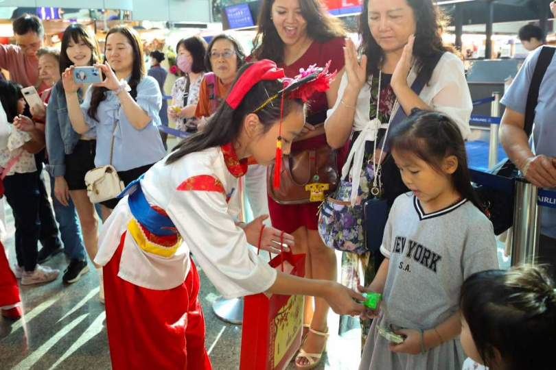 金門中正國小鼓吹隊員與旅客互動，分享來自金門的文化熱情。（圖／財團法人昇恒昌基金會提供）