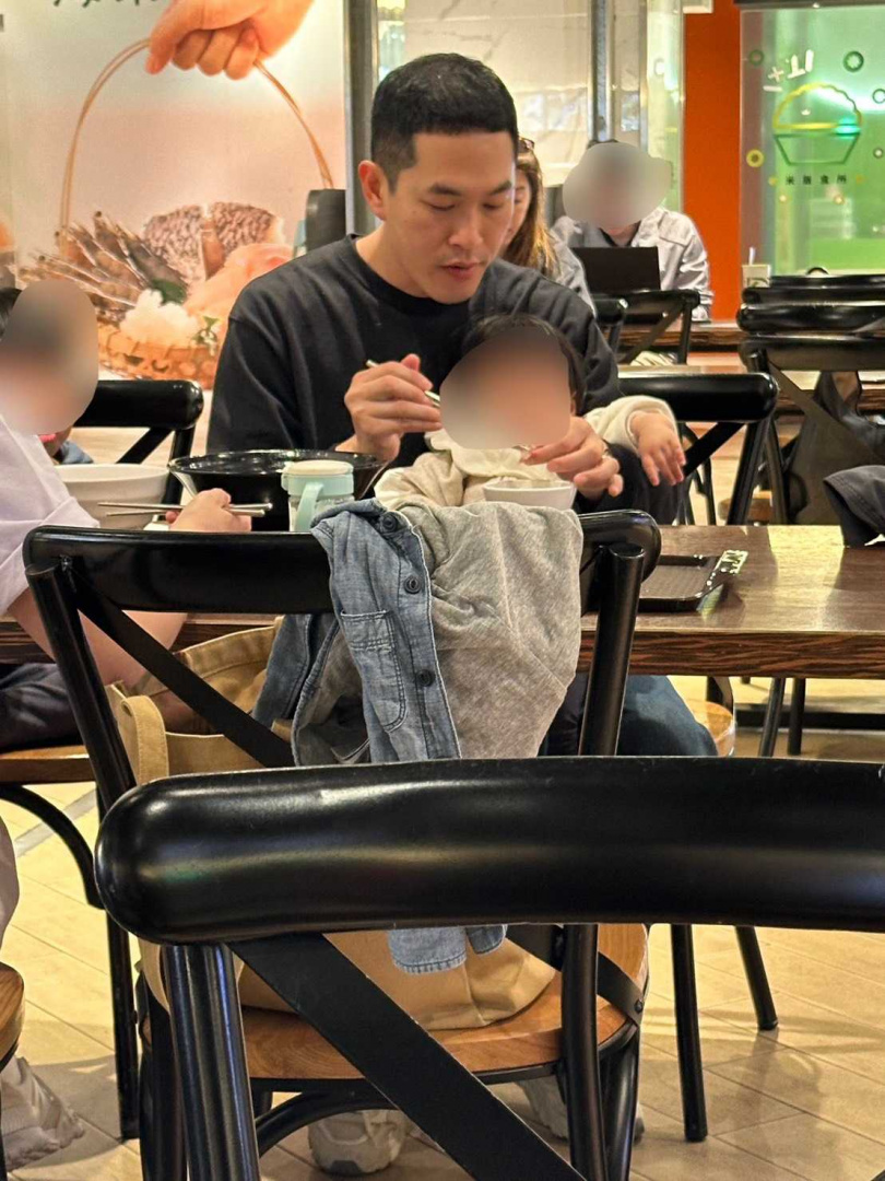 阿奎一邊吃飯一邊餵女兒,看起來相當熟練。(圖/讀者提供)