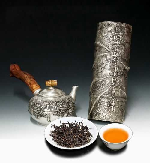 金工藝術家蔡長宏以陽刻詩句鍛造的銀壺與銀茶則。(圖/吳德亮攝)