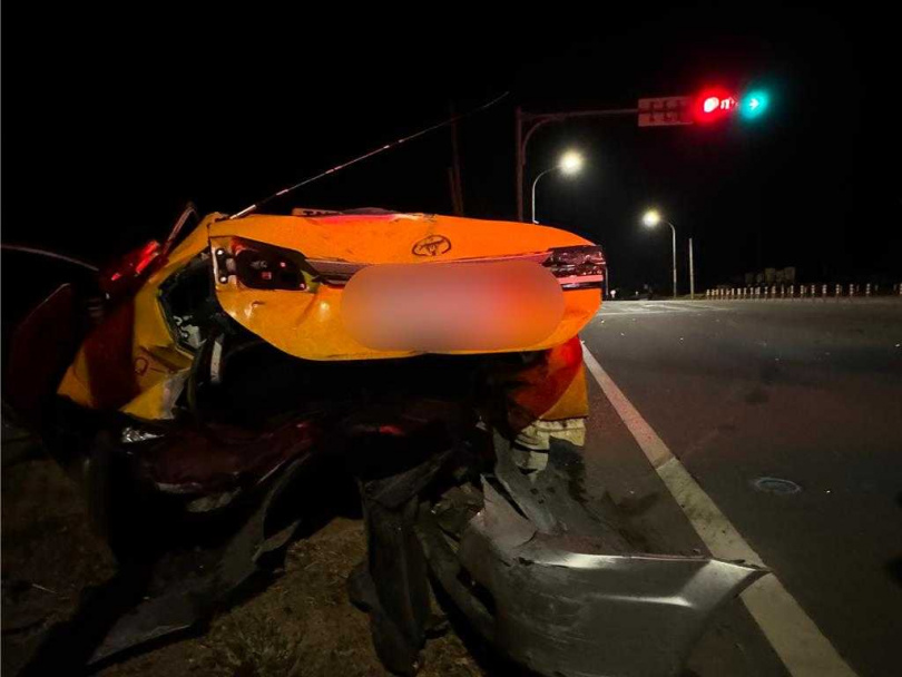   停等紅燈的計程車，遭後方車輛猛烈追撞後噴飛10多公尺衝入邊坡，車尾全毀。(圖／中國時報于家麒攝)