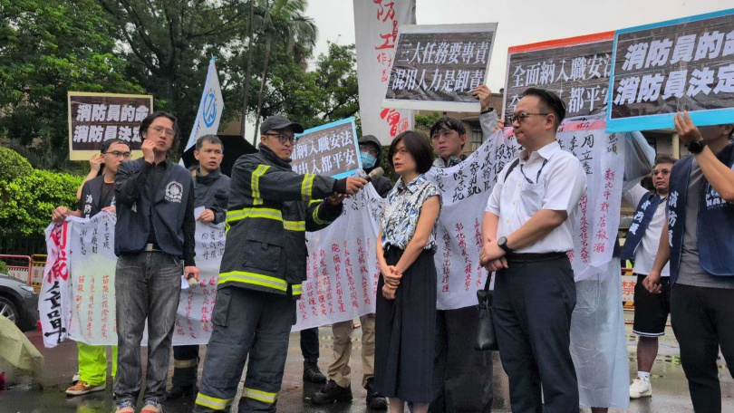 消防員工作權益促進會9日上午於行政院前抗議，行政院內政衛福勞動處參議吳婉慧出面代表接受陳情。（圖／林冠吟攝）