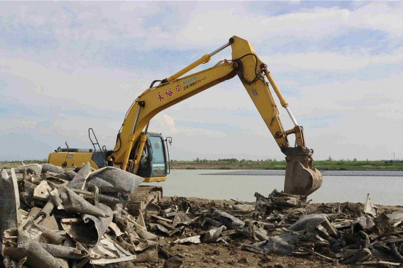 今怪手仍持續挖除池邊的廢光電設施。（圖／中國時報呂妍庭攝）