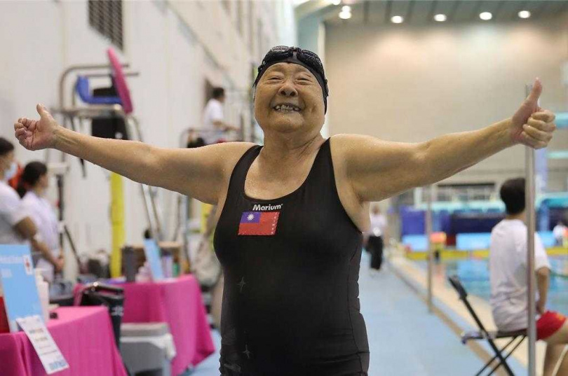 雙北世界壯年運動會18日進行游泳項目競賽，97歲的唐成瑤參加50公尺蛙式游泳項目，獲得觀眾熱情掌聲為她加油。唐成瑤比完賽後，高舉雙手喊「中華民國萬歲」。（圖／中國時報黃世麒攝）