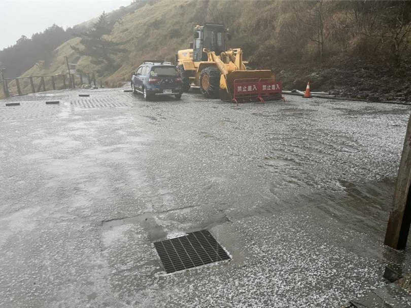 合歡山區降雷雨伴隨冰雹，冰雹覆蓋路面，台14甲線31公里處有車輛因路面積冰打滑受困。（圖／林保署南投分署提供）