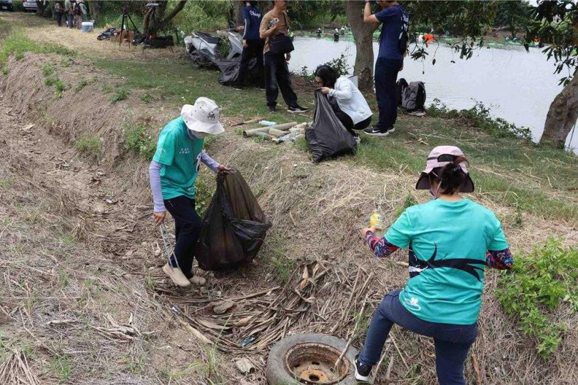 水中作業的同時，志工夥伴在陸地清理陳年堆積於護岸上的垃圾。（圖／翻攝畫面）