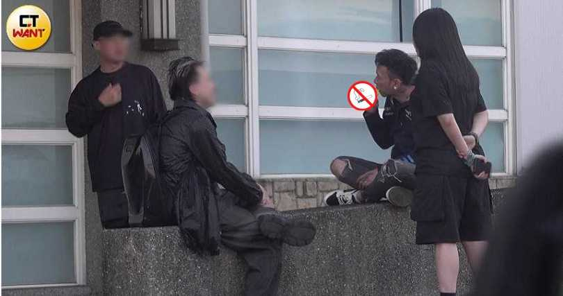 頑童MJ116成員小春在校唱空檔時，與工作人員一起在校園內抽菸。（圖／本刊攝影組）