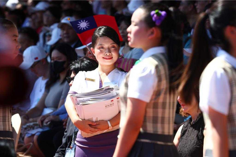 中華民國114年國慶大典10日登場，活動進行時，禮賓人員抱著整疊的資料準備發送給貴賓。（圖／中國時報鄧博仁攝）