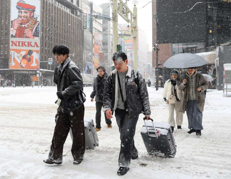日本海側地區風雪交加，當地居民冒雪出行。