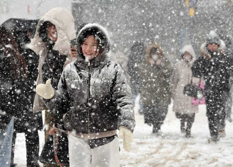 日本海側地區風雪交加，當地居民冒雪出行。