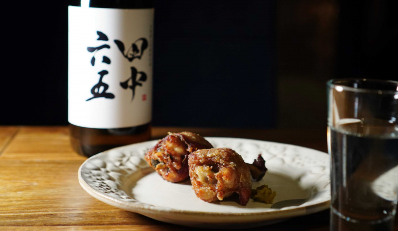 剛炸好的「黑羽土雞二節炸雞」外脆內多汁，搭配「田中六五 糸島山田錦純米酒」可以中和炸物的油膩並延續甜感。（圖／魏妤靜攝）