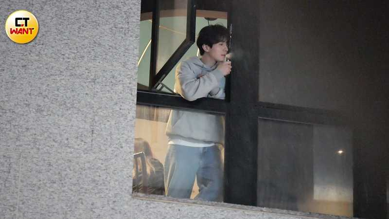 飽餐後的李棟旭走到窗邊，望著街景抽菸放鬆心情。（圖／本刊攝影組）