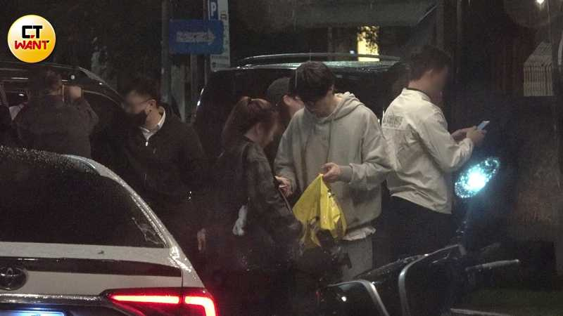 李棟旭續攤桌遊酒吧途中，從手提袋取出餅乾送給身旁女性。（圖／本刊攝影組）