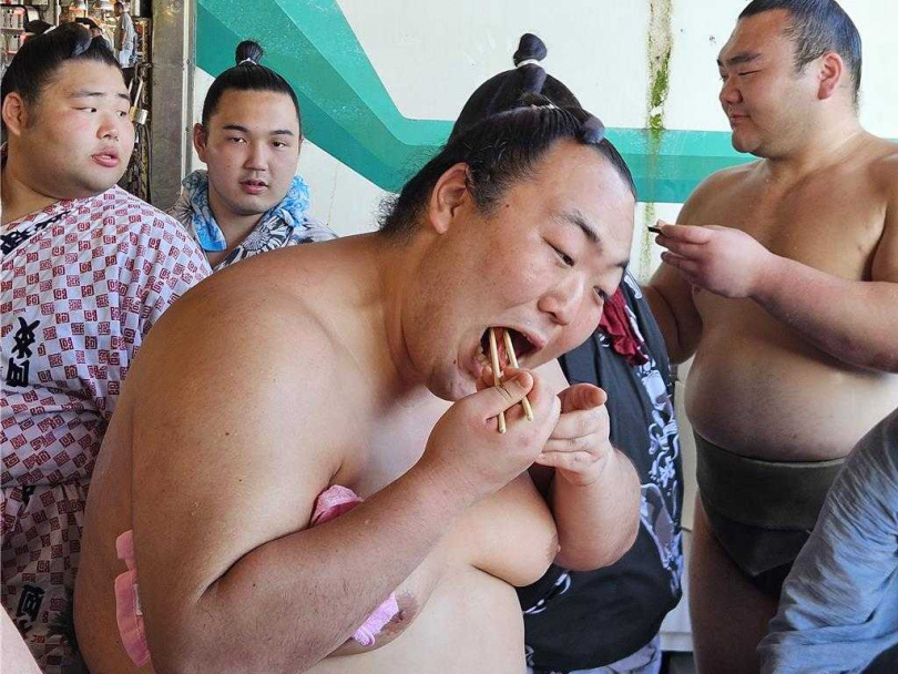 日本相撲力士大啖黑鮪魚,紛紛豎起大姆指稱讚。(圖/中國時報羅琦文攝)