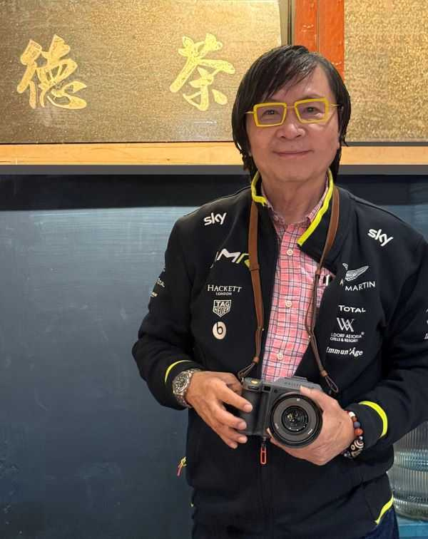 本文作者與「大橋町」收藏的「德茶」舊匾。（圖／吳德亮攝影）