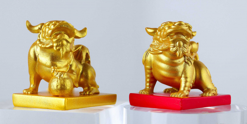 「有求必應」（左）「腳踏實地」（右）紀念吊飾以媽祖鑾轎上的金獅作為造型，設計兩款酒瓶吊飾，並以盲盒概念隨機放入酒品禮盒之中，增添收藏價值。（圖／泰山提供）。