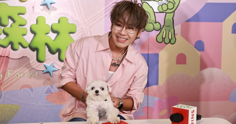 JINS友善動物大使鼓鼓呂思緯，帶著愛犬小柱開心體驗《動物友好樂園：魔法療癒森林》展覽，將掌印蓋上鏡片做的許願幣。（圖片提供／JINS）