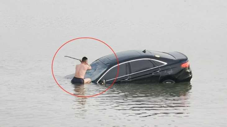 汽車失控墜入湖中,正值生死關頭,一名男子用嘴巴叼住撬棍,脫下衣服跳進湖中,砸破車窗救人。(圖/翻攝自微博)