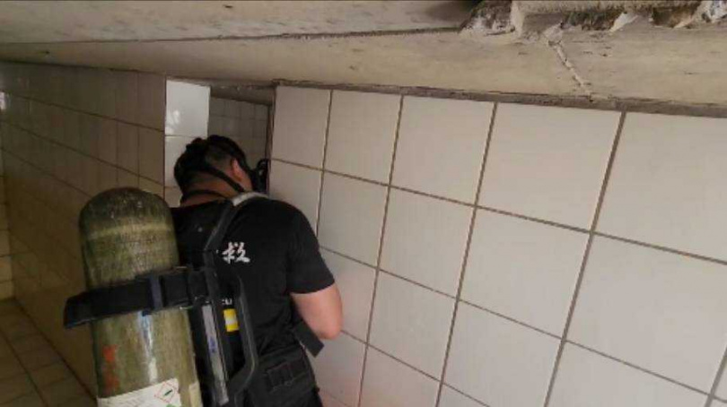 警消進入水塔後,確認K男遺體狀況,設法運出水塔。(圖/翻攝畫面) 