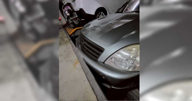 住戶周先生將車停妥後按下復歸鍵,不料疑因感應問題,導致車頭卡在平台牆面。(圖/投訴人提供)