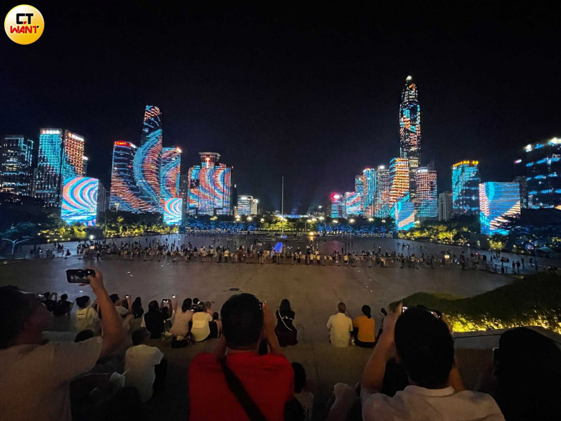 每周五及周六晚上，深圳市民廣場四圍樓群上演三場燈光秀，成了深圳夜間親子樂打卡景點。（圖／何曼卿攝）