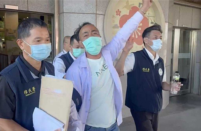 陸籍盧男在專勤隊員「護送」下，登船途中仍不斷舉手高喊「打倒台獨」、「獨裁」、「兩岸和平統一」等口號。（圖／翻攝畫面）