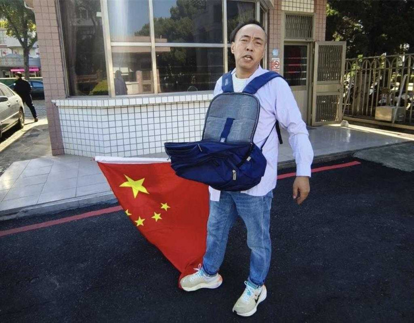 大陸盧姓男子今早扛著自己整合縫製之中華民國與大陸五星旗幟，隻身闖入縣府大門高喊「兩岸統一」並丟撒傳單，被移民署專勤隊帶回訊後已遭遣返。（圖／翻攝畫面）