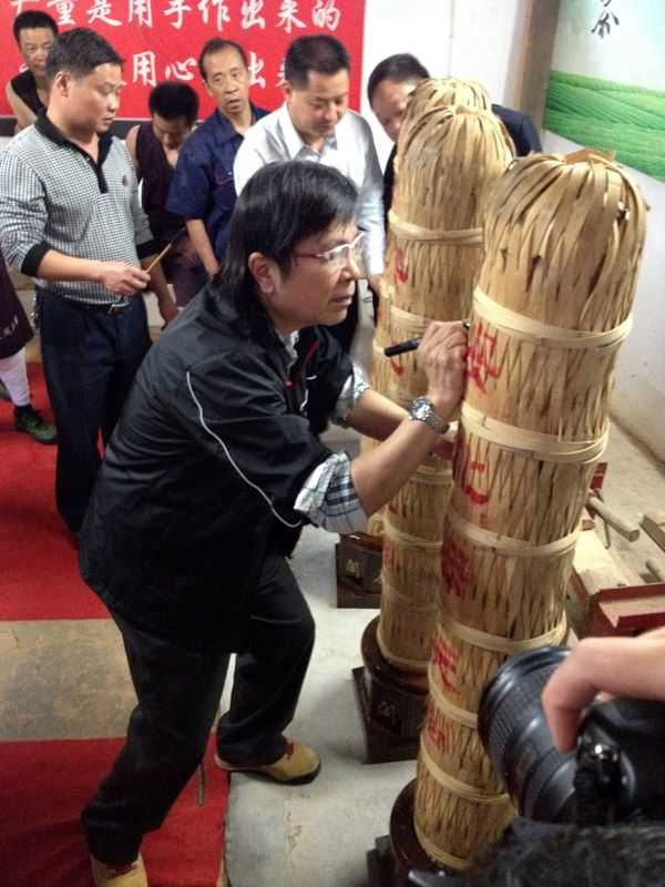 本文作者吳德亮在雲天閣新製作完成的千兩茶上簽名。(圖/吳德亮攝影)