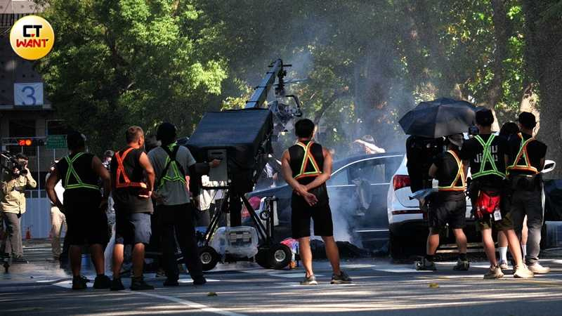 4旁邊的賓士道具轎車冒著白煙，滿臉血的演員躺在地上。（圖／本刊攝影組）