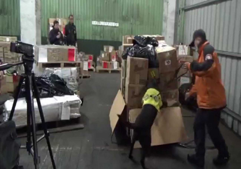 警方接獲情資,於貨櫃內搜出大量紙箱,並在紙箱內查獲大量裝有毒品與槍枝的精品包。(圖/翻攝畫面)