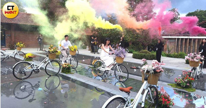 戶外證婚場地原本是一個戶外泳池,經過填平成為戲水池畔,圖為創意婚禮新人騎自行車進場。(圖/林榮芳攝)