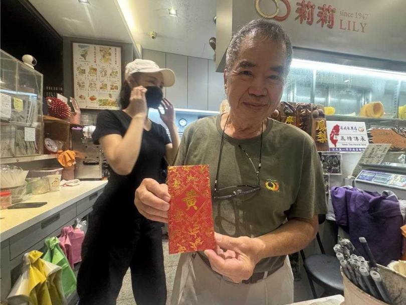 黃仁勳送一個大紅包給莉莉水果店，讓老闆李文雄很驚喜。（圖／中國時報曹婷婷攝）