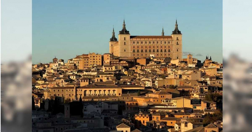 譚明珠分享,上方大型城堡建築為托雷多著名地標托雷多城堡;下方則是托雷多古城區的密集石屋與屋頂景觀。(圖/譚明珠提供)