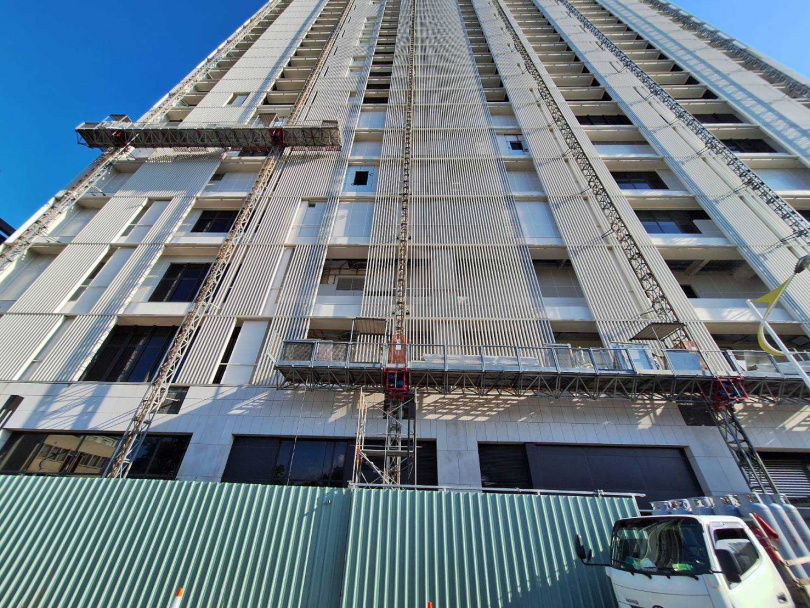 去年403地震，潔西艾美外牆出現多處裂痕、剝落，記者實地走訪，至今已過去1年半，外牆仍在修繕中。（圖／林榮芳攝）