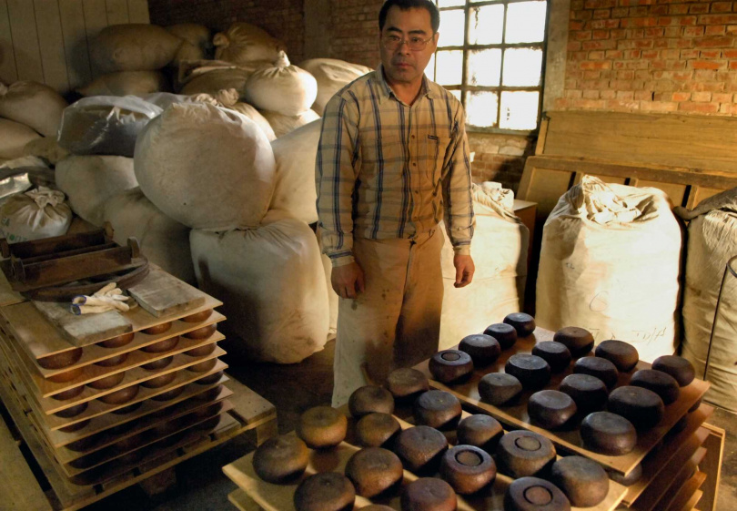 福源茶廠第三代掌門黃文諒與他光滑渾圓且無鐵絲痕的酸柑茶。(圖/吳德亮攝)