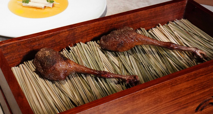 「香炸乳鴿腿」於酥脆外皮又灑上孜然、丁香與甘草等香料粉，掀開盒蓋還有煙燻香氣飄出。（圖／魏妤靜攝）