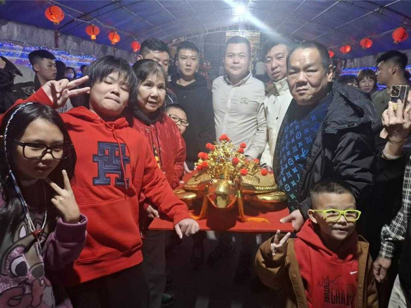 2025年2月14日澎湖縣/澎湖鎖港北極殿的260兩黃金龜,14日晚由綽號「曾鐵霸」的天道盟盟主曾盈富(中)母親曾韓金桂以六相杯乞得,曾鐵霸一家開心合影。(圖/中國時報許逸民攝)