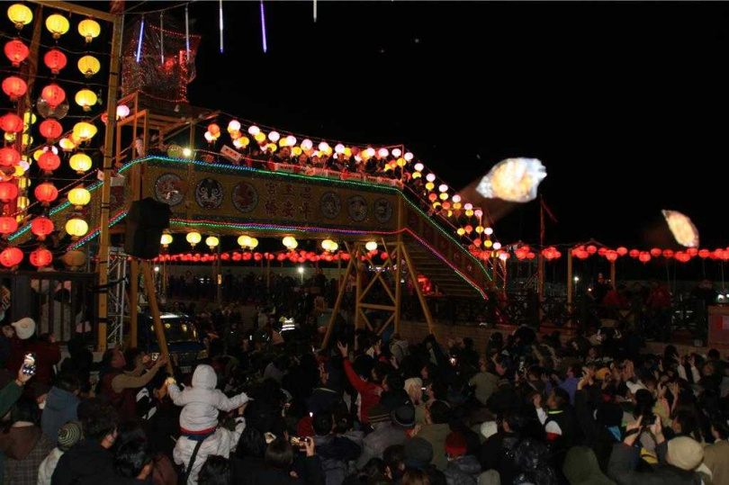 2025年2月14日澎湖縣/澎湖外垵溫王宮的元宵戶外活動,去年因平安橋上硬幣擲吉時誤傷台中女遊客眼球,今年廟方就不再擲硬幣,反而大手筆將600張百元大鈔夾帶在麻糬中拋擲。(圖/中國時報許逸民攝)