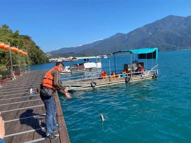   縣府環保局稽查人員採集水樣，調查日月潭汙染物並追查汙染源，並用吸油棉清理泡沫等汙染。（圖／南投縣政府提供／中國時報楊靜茹南投傳真）