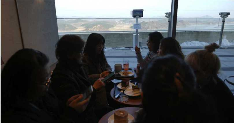 店內客人一邊享用咖啡，一邊透過大片落地窗眺望北韓黃海道開豐郡。（圖／達志／美聯社）