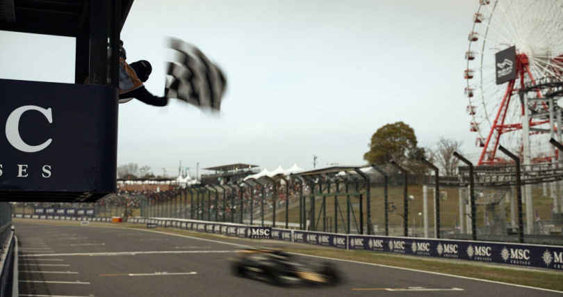 《F1電影》虛構的「APXGP車隊」的兩輛賽車，在2023年英國大獎賽銀石賽道站，真的跟著20位專業賽車手在起跑區排隊，跑完暖胎圈。（圖／華納兄弟提供）