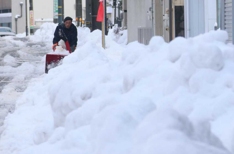 日本青森地區街道兩旁堆滿雪牆，道路通行困難。