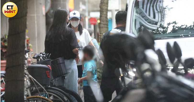 安以軒跟女助理在診所外，看起來是在等待醫生叫號。她走到白色豪車旁接小孩，由司機幫忙開車門並扶小孩下車。（圖／本刊攝影組）