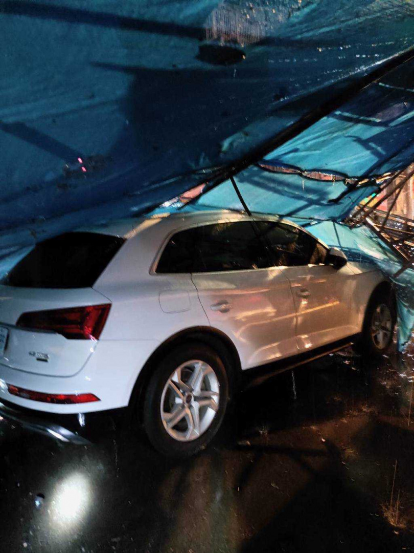 新北市中和區民樂路一處建案不敵今（22）日晚間的強風豪雨，傳出有鷹架倒塌意外，長10公尺、寬5公尺的施工鷹架突然坍塌，壓毀路邊一輛轎車。（圖／翻攝畫面）