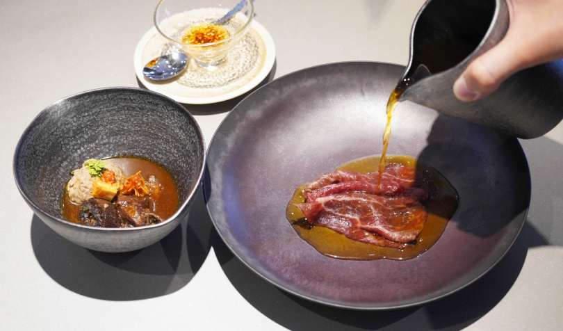 「近江牛／consommé／枸杞」以汆燙方式淋入法式澄清熱湯，和牛油脂也沒浪費，與鹹香培根、蒜頭一起製成提味辣油。（圖／魏妤靜攝）