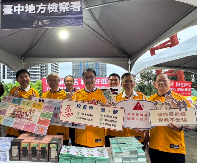 法務部鄭銘謙部長（圖中）到洲際球場宣導打詐反毒反賄選，在反詐詐宣導攤位前以標語提醒民眾打詐重要性。（圖片提供/中信兄弟）