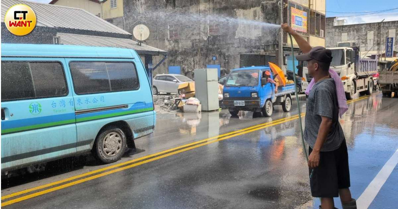 有災民在家園完成初步清理後，從家裡拉出長長的水管，為路過的每輛車洗去髒汙。（圖／林冠吟攝）