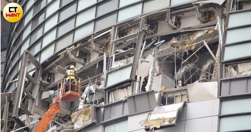 大型吊車進駐新光三越台中中港店,工人將外牆上較危險的懸空建材移至室內,避免掉落造成二次災害。(圖/黃耀徵攝)