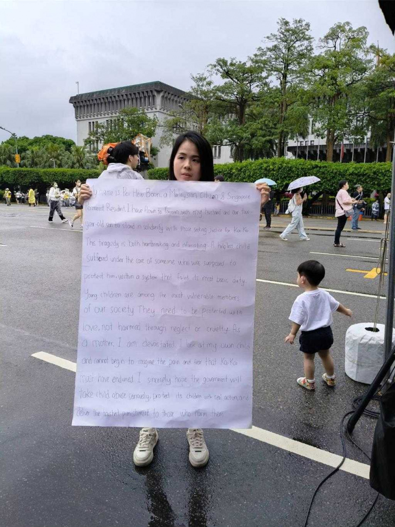 來自馬來西亞的彭媽媽帶著2歲孩子與丈夫特地飛來參與，自己撰寫大字報，盼能為台灣兒童保護能盡一份心力。（圖／中國時報李侑珊攝）